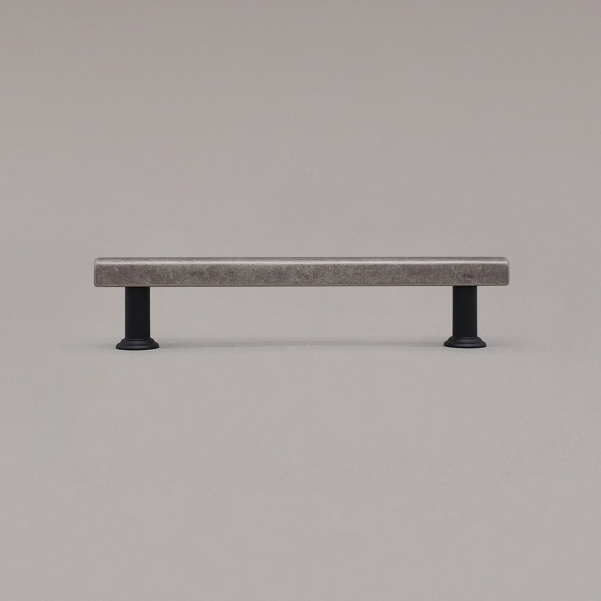 medium weathered nickel and matte black mod cabinet pull standing on gray background