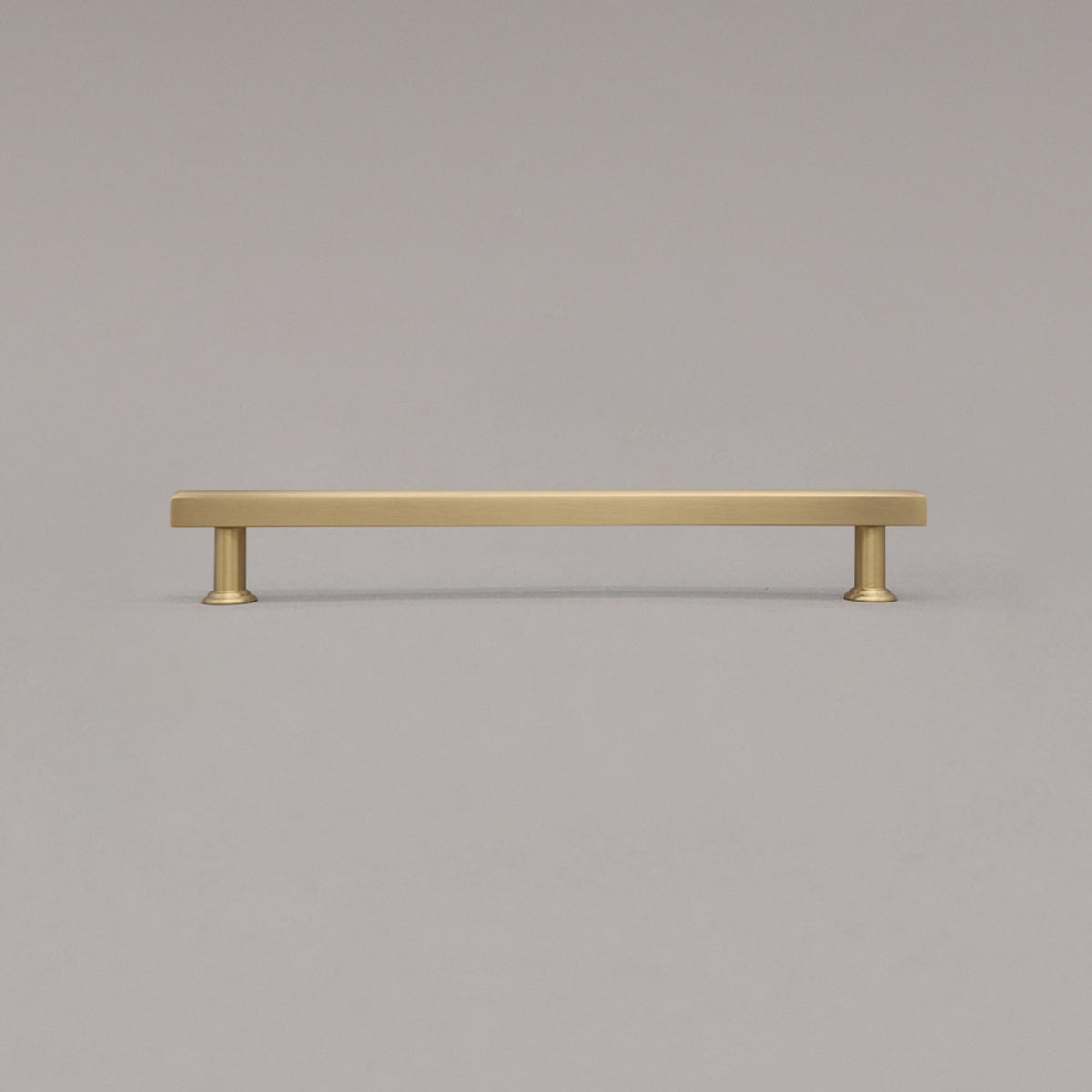 large satin brass mod cabinet pull standing on gray background