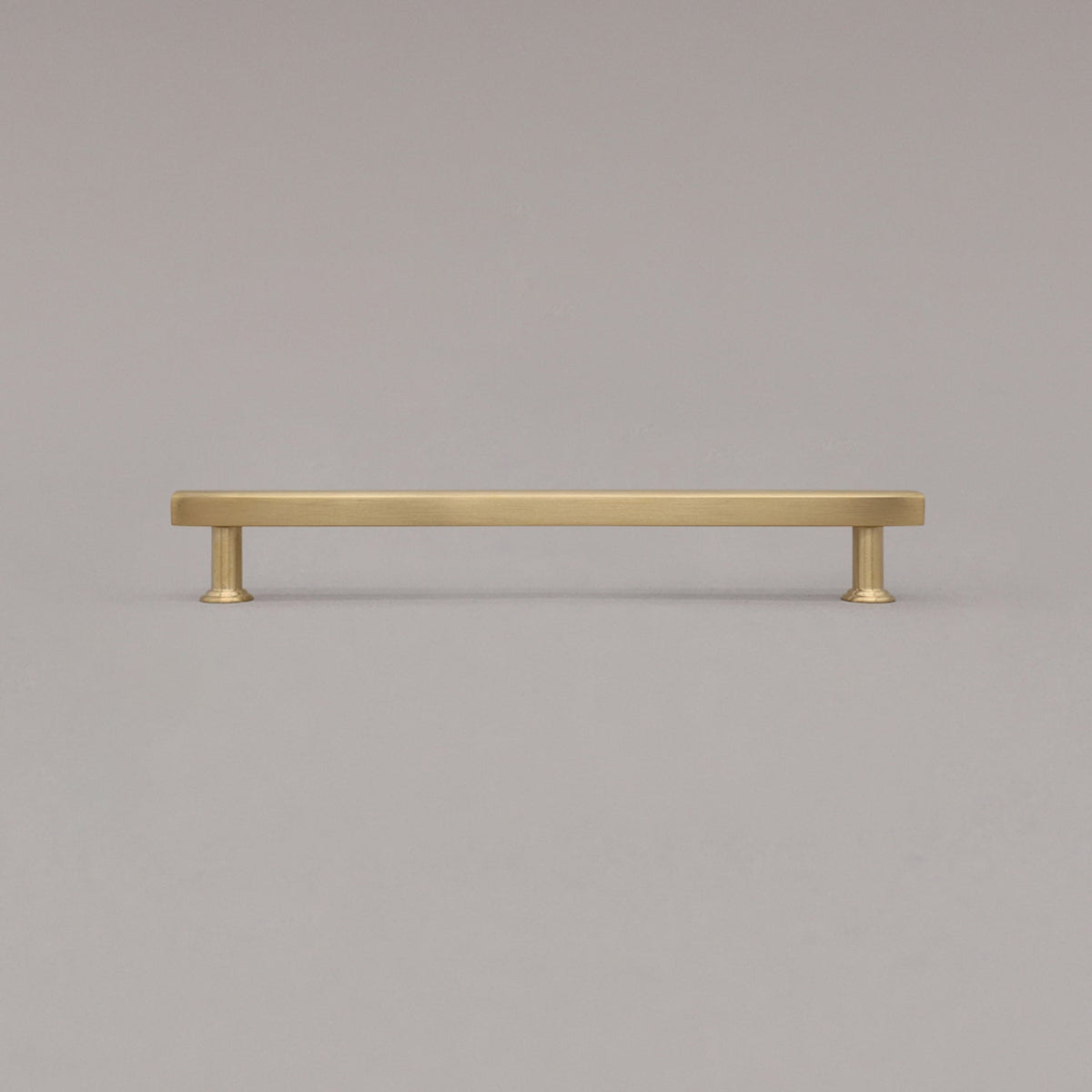 large unlacquered satin brass mod cabinet pull standing on gray background