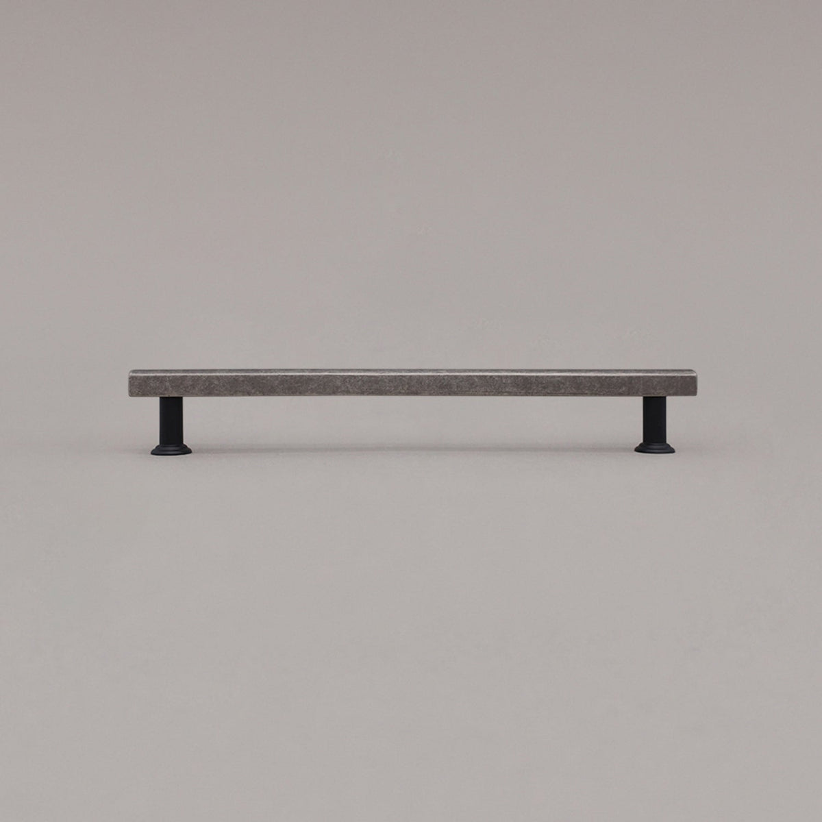 large weathered nickel and matte black mod cabinet pull standing on gray background