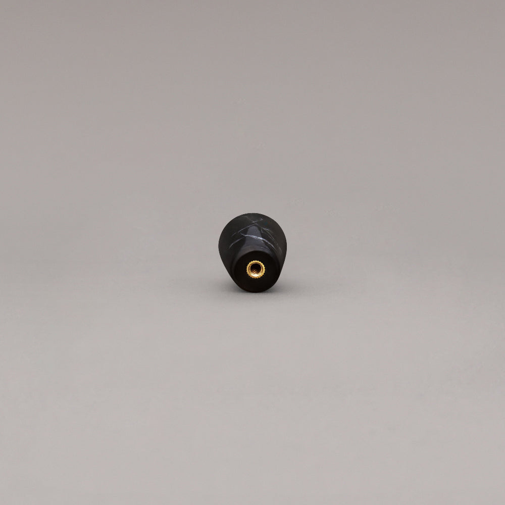 rear view of black marble cone knob on gray background