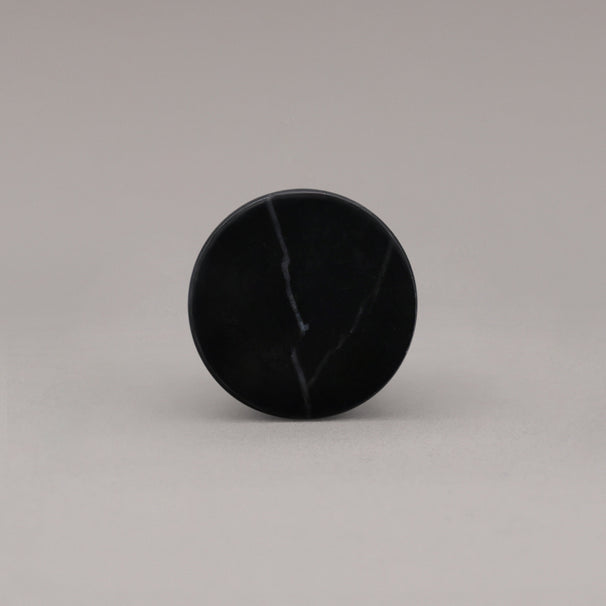 front view of black marble cone knob on gray background