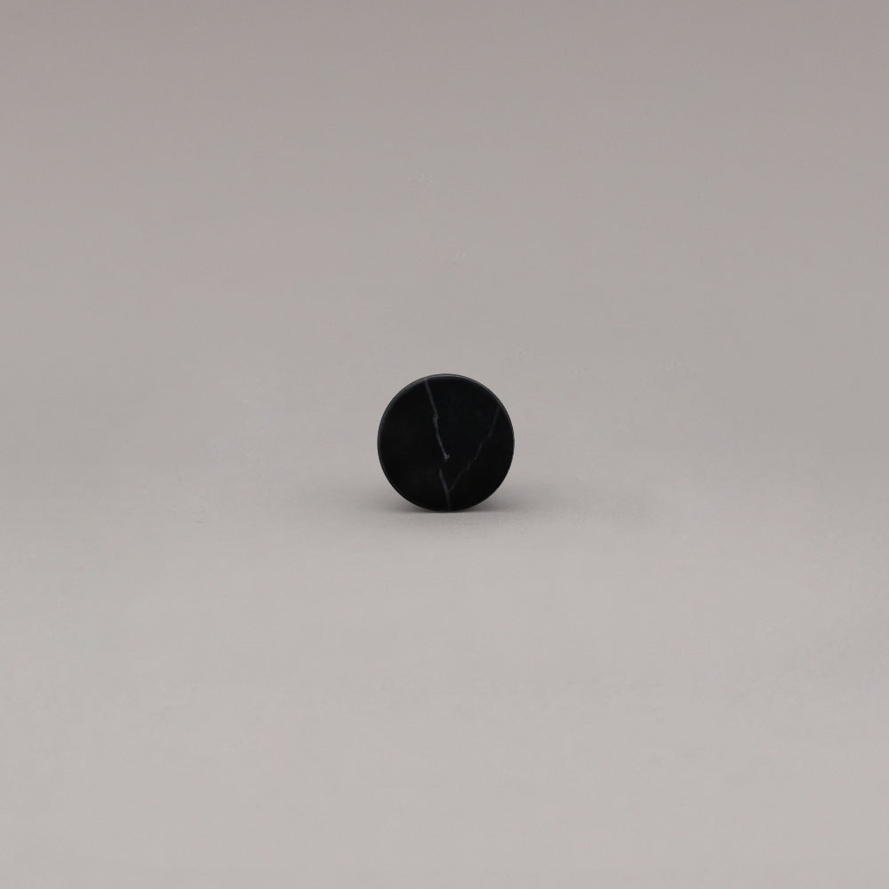 front view of black marble cone knob on gray background