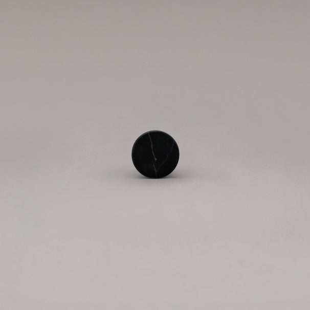 front view of black marble cone knob on gray background