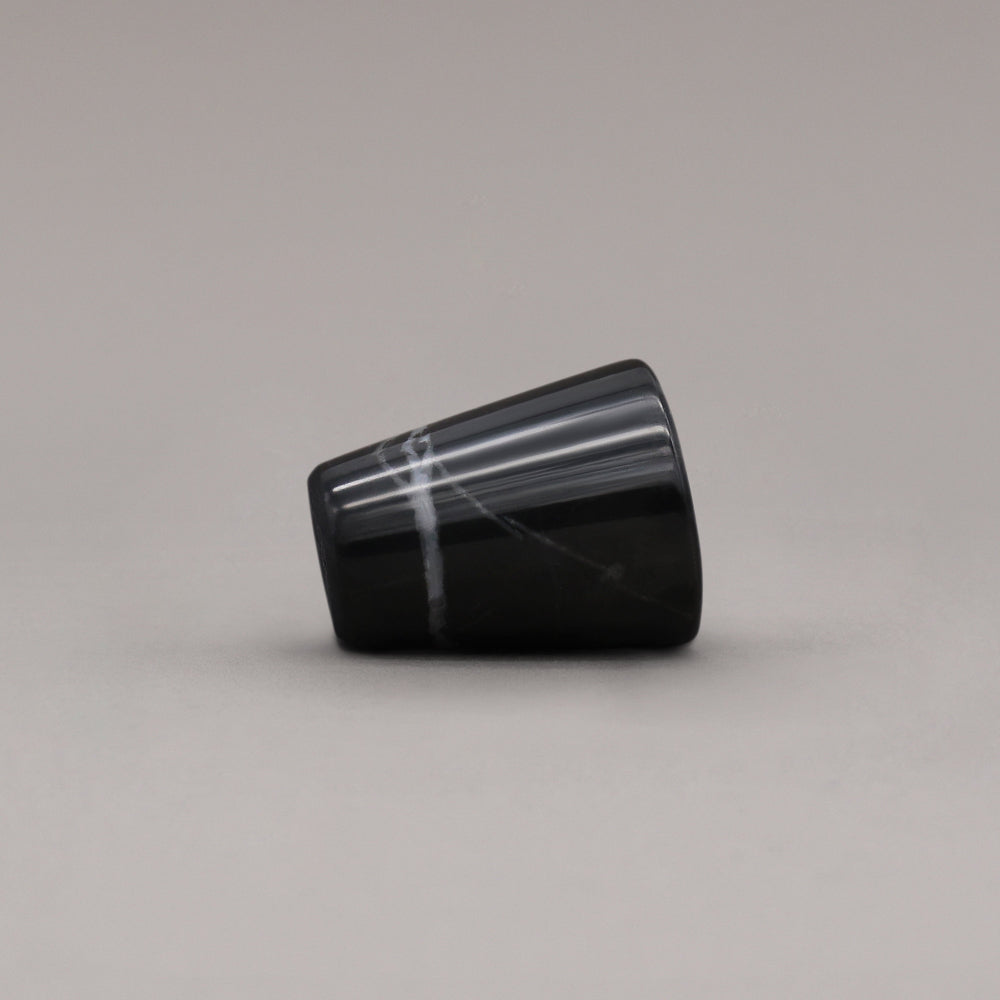 side view of black marble cone knob on gray background