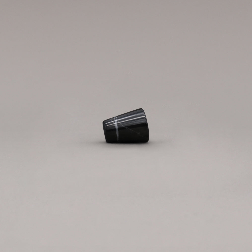 side view of black marble cone knob on gray background