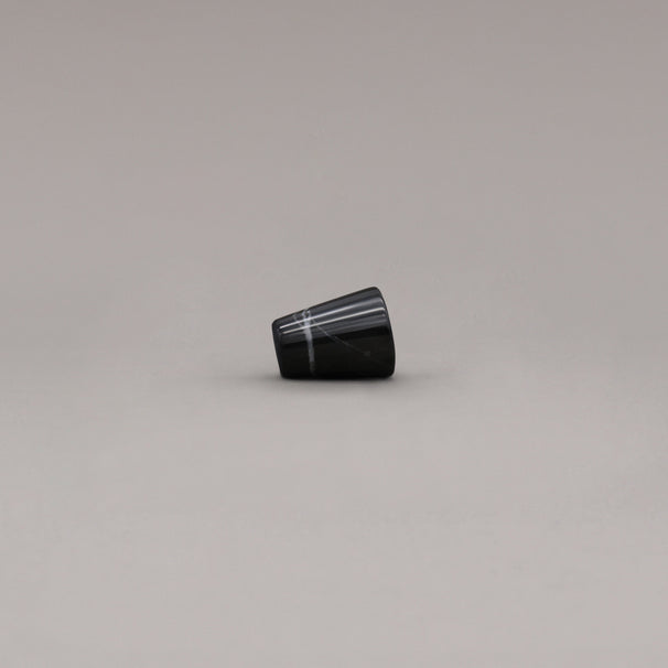 side view of black marble cone knob on gray background