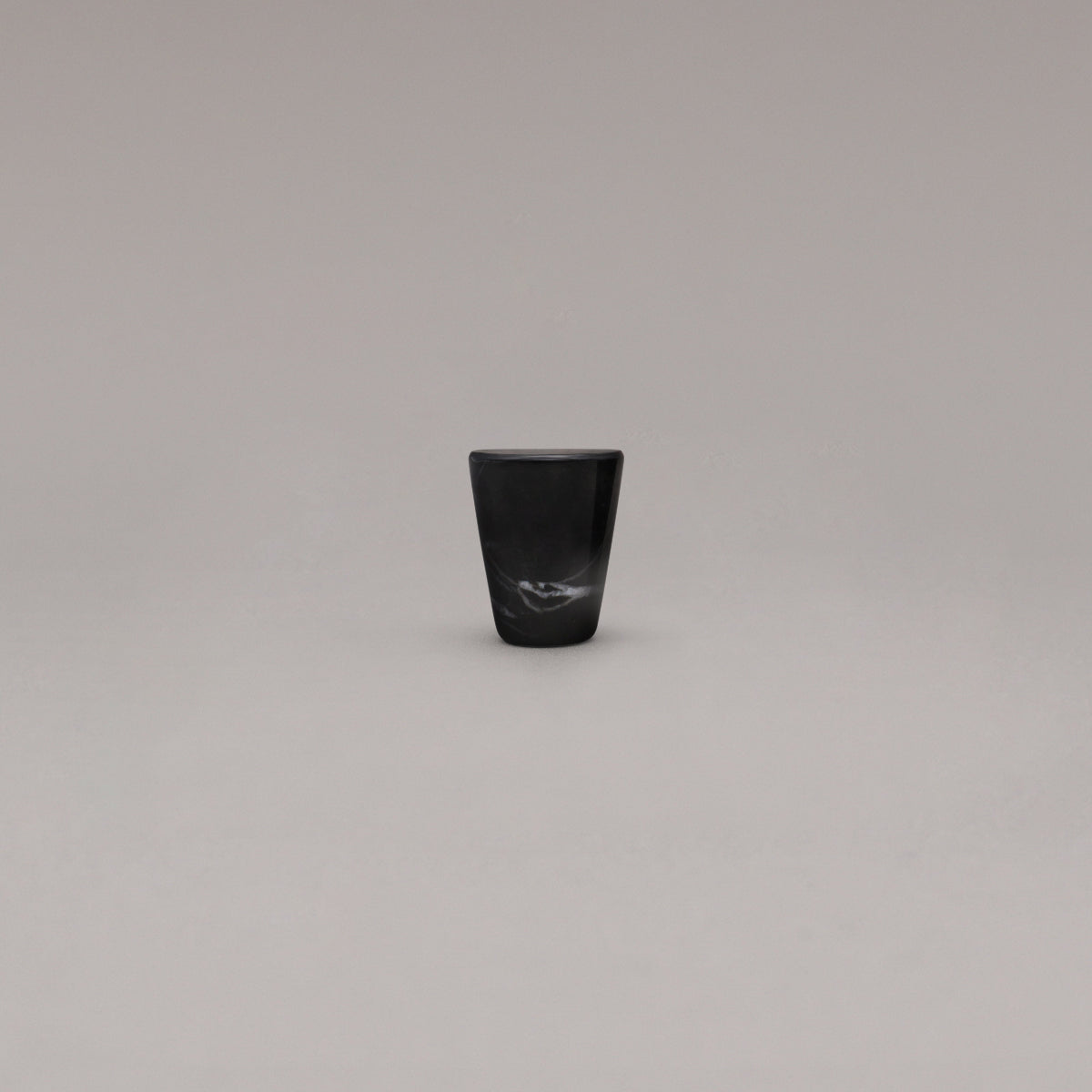 black and white marble cone knob standing on gray background