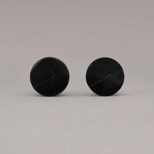 front view of two black marble cone knobs on gray background