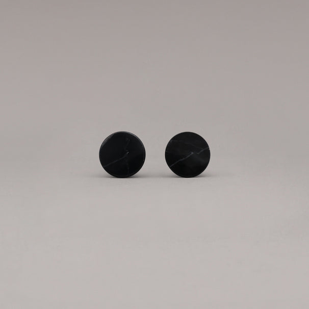 front view of two black marble cone knobs on gray background