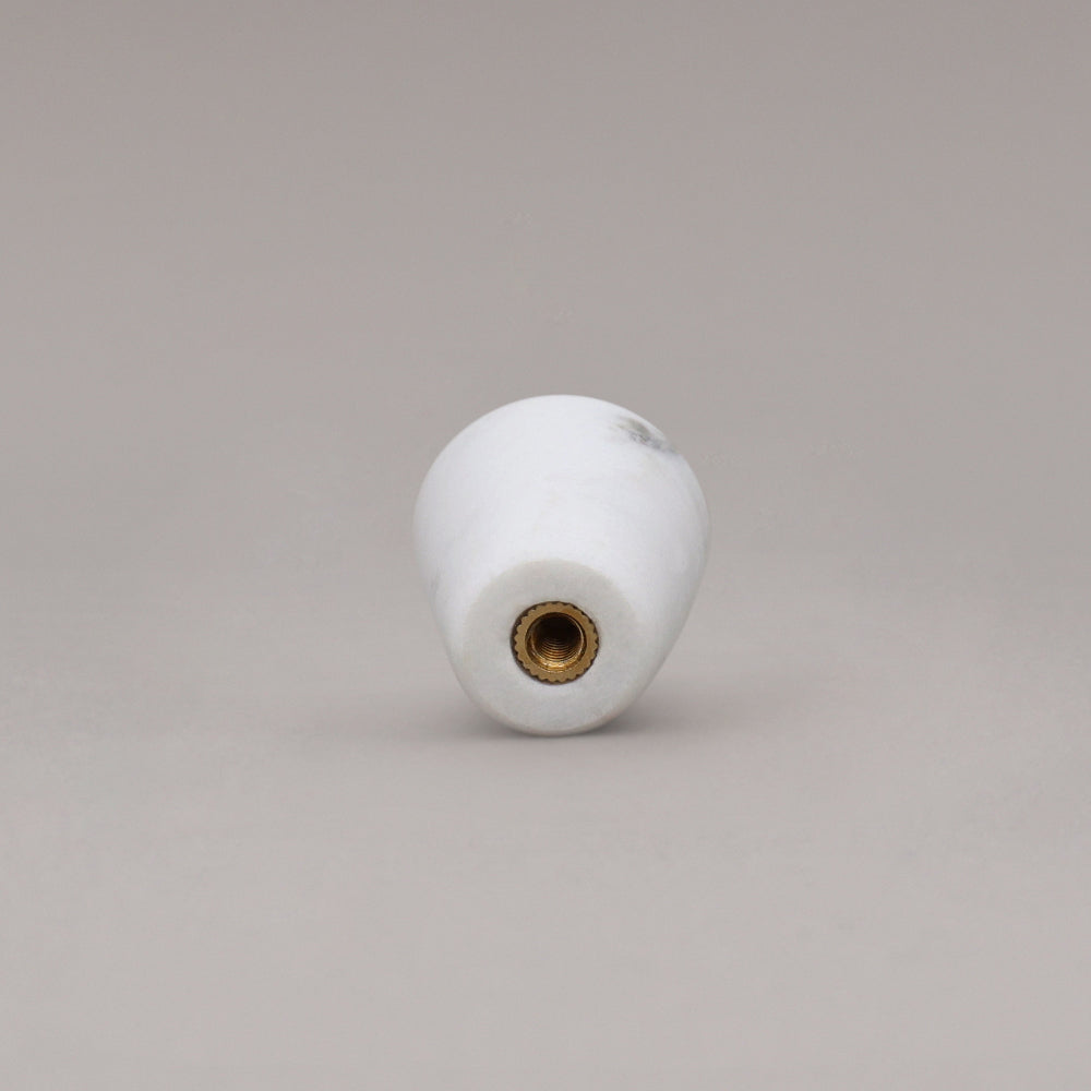 rear view of white carrara marble cone knob on gray background