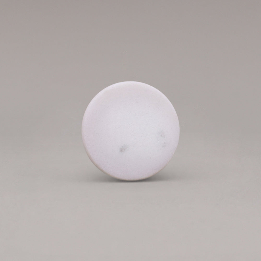 front view of white carrara marble cone knob on gray background