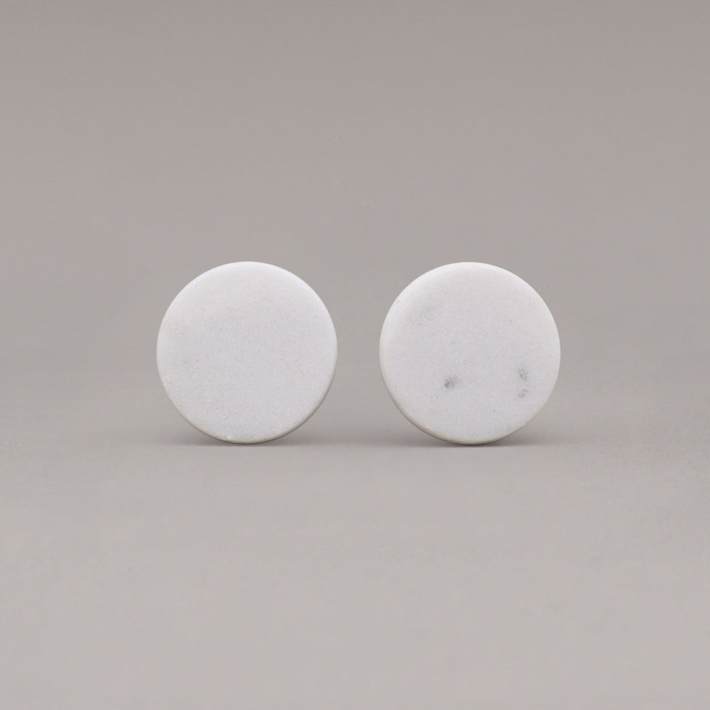 front view of two white carrara marble cone knobs on gray background