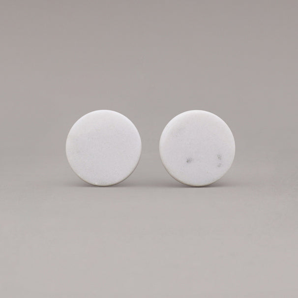 front view of two white carrara marble cone knobs on gray background