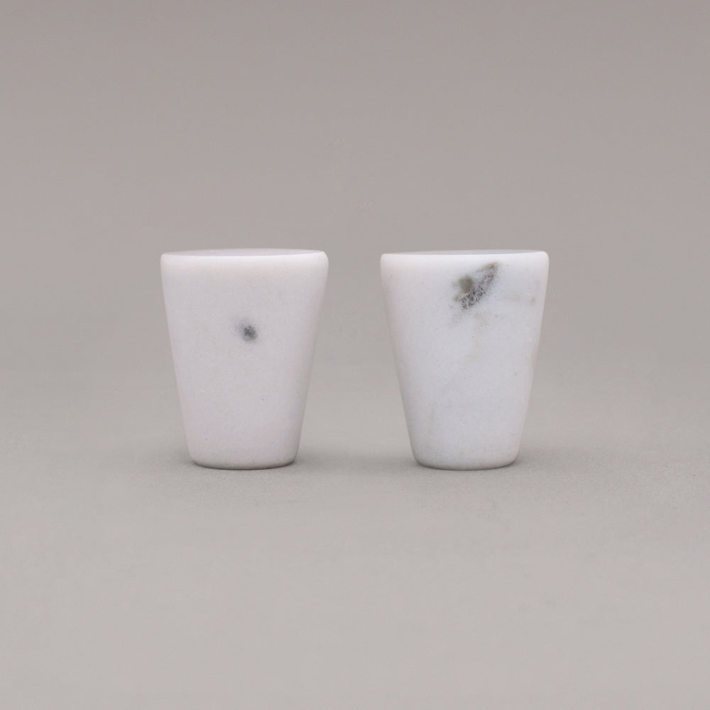 two white carrara marble cone knobs standing on gray background