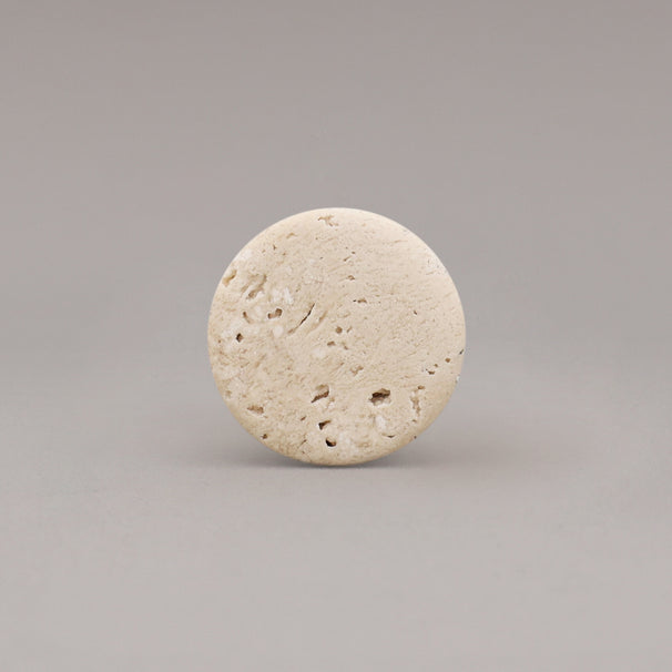 front view of travertine marble cone knob on gray background