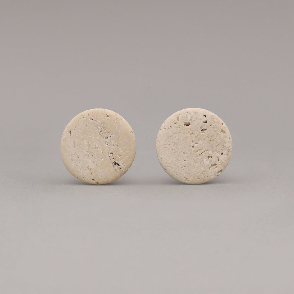 front view of two travertine marble cone knobs on gray background