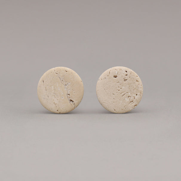 front view of two travertine marble cone knobs on gray background