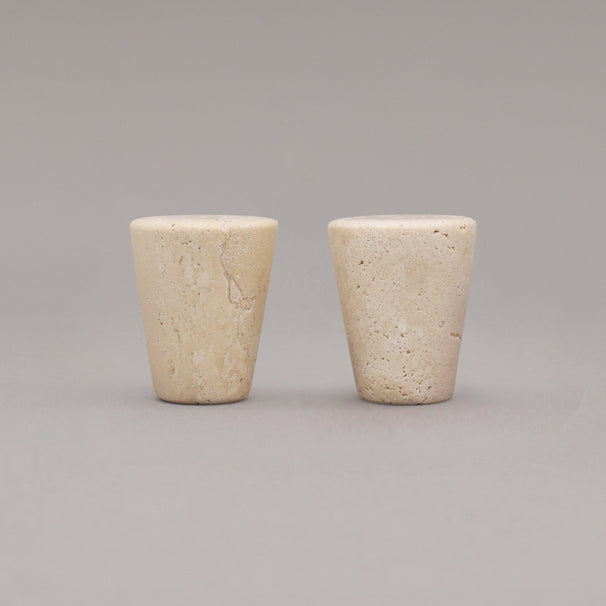 two travertine marble cone knobs standing on gray background