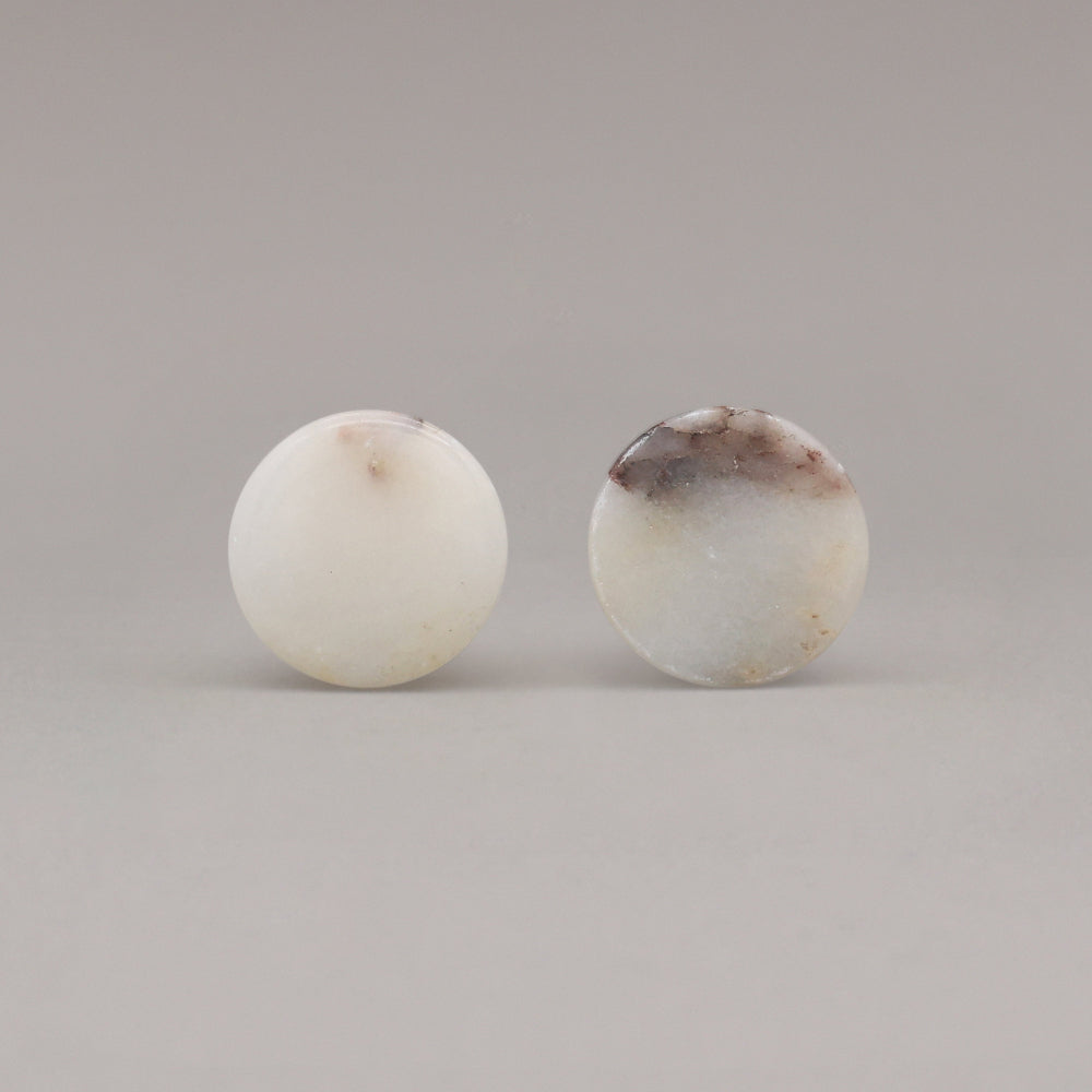 front view of two calacatta viola marble cone knobs on gray background