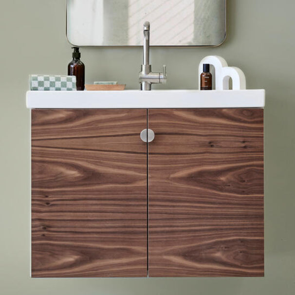 half moon satin nickel silver knobs installed on darker wood bathroom vanity