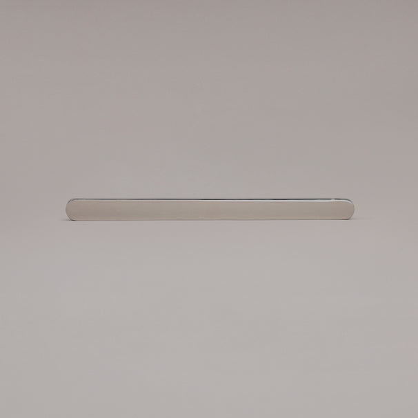 12" Ribbed appliance pull in Polished Nickel laying on gray background