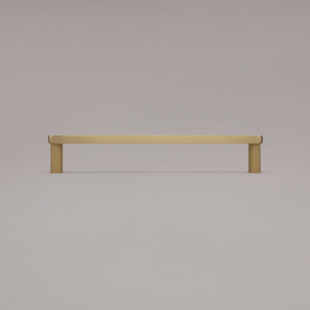 12" Ribbed appliance pull in Satin Brass standing on gray background