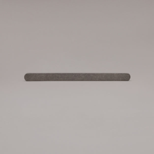 12" Ribbed appliance pull in Weathered Nickel laying on gray background