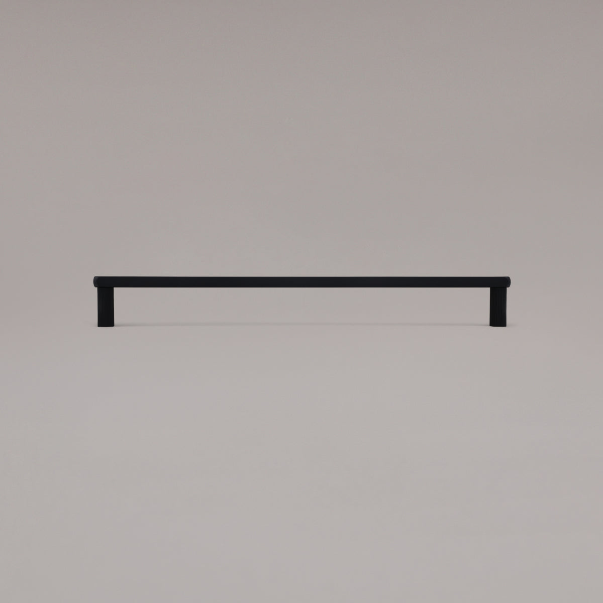 18" Ribbed appliance pull in Matte Black standing on gray background