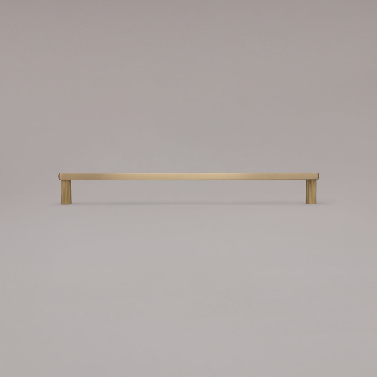 18" Ribbed appliance pull in Satin Brass standing on gray background