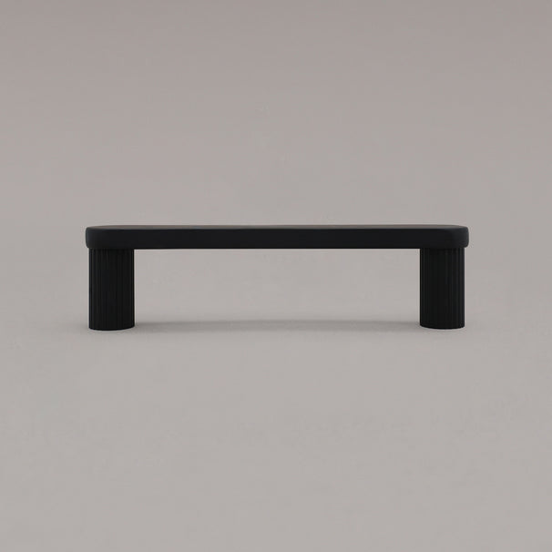 small matte black ribbed pull standing on gray background