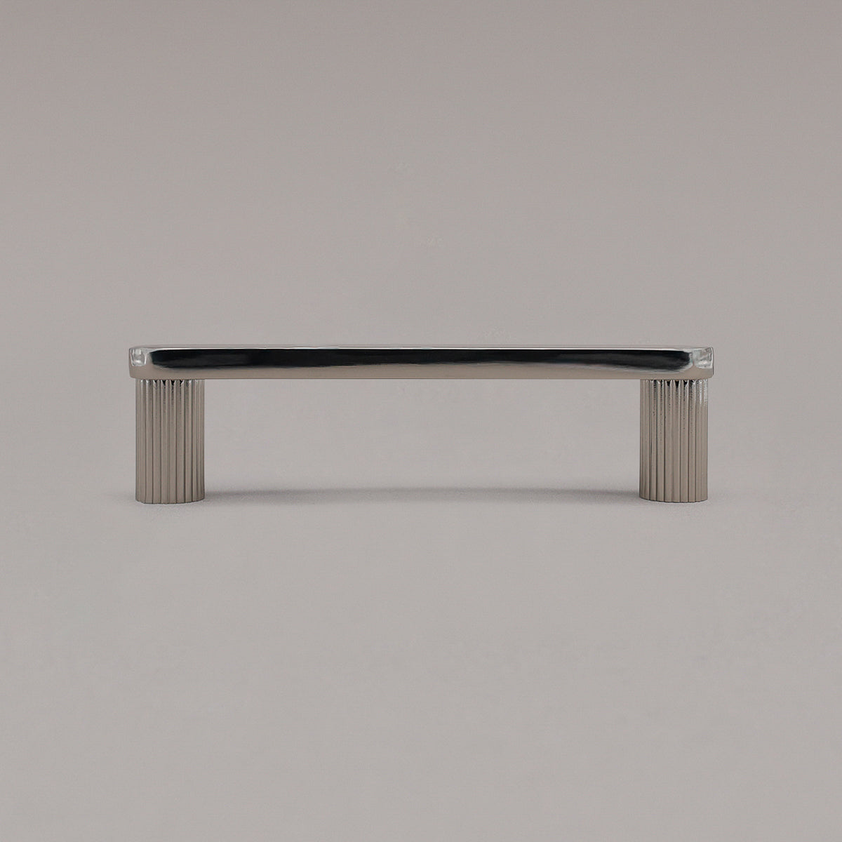 small polished nickel ribbed pull standing on gray background