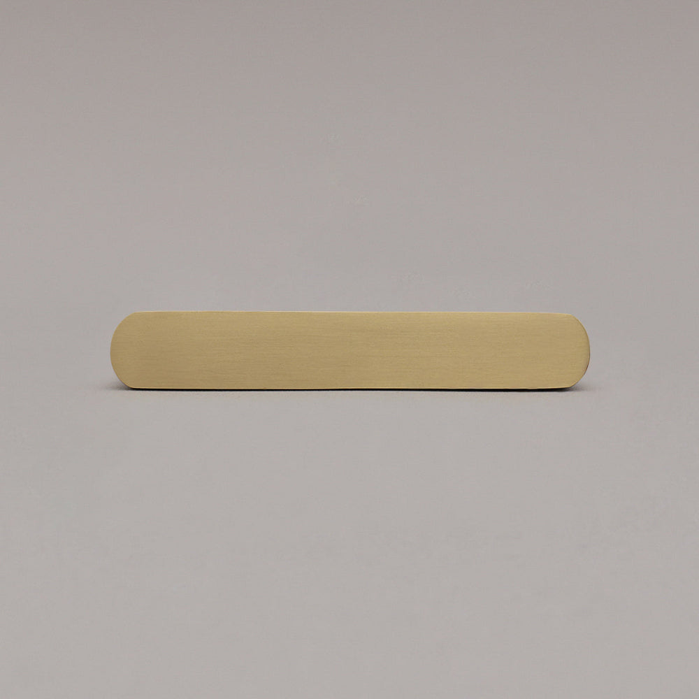 front view of small satin brass gold ribbed pull on gray background