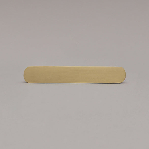 front view of small satin brass gold ribbed pull on gray background