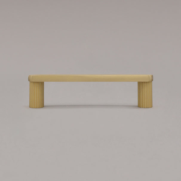 small satin brass gold ribbed pull standing on gray background