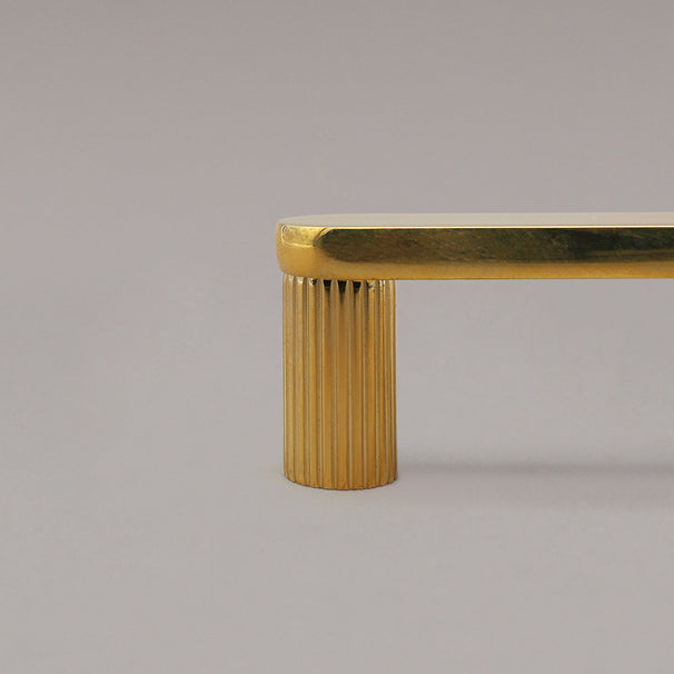 close up of unlacquered polished brass ribbed cabinet pull stem 