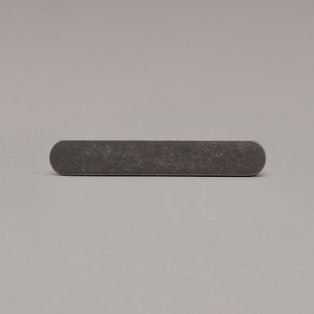 front view of small weathered nickel ribbed pull on gray background