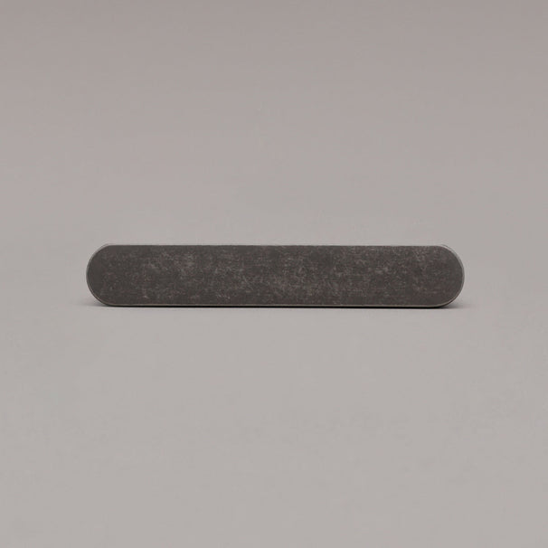 front view of small weathered nickel ribbed pull on gray background