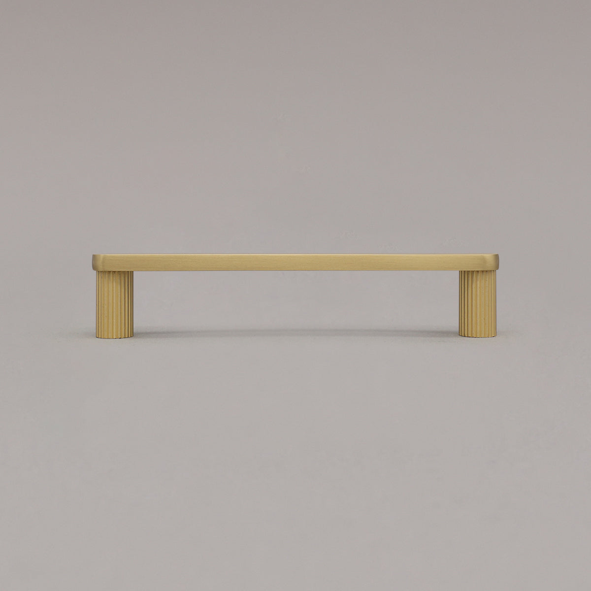 medium satin brass gold ribbed pull standing on gray background