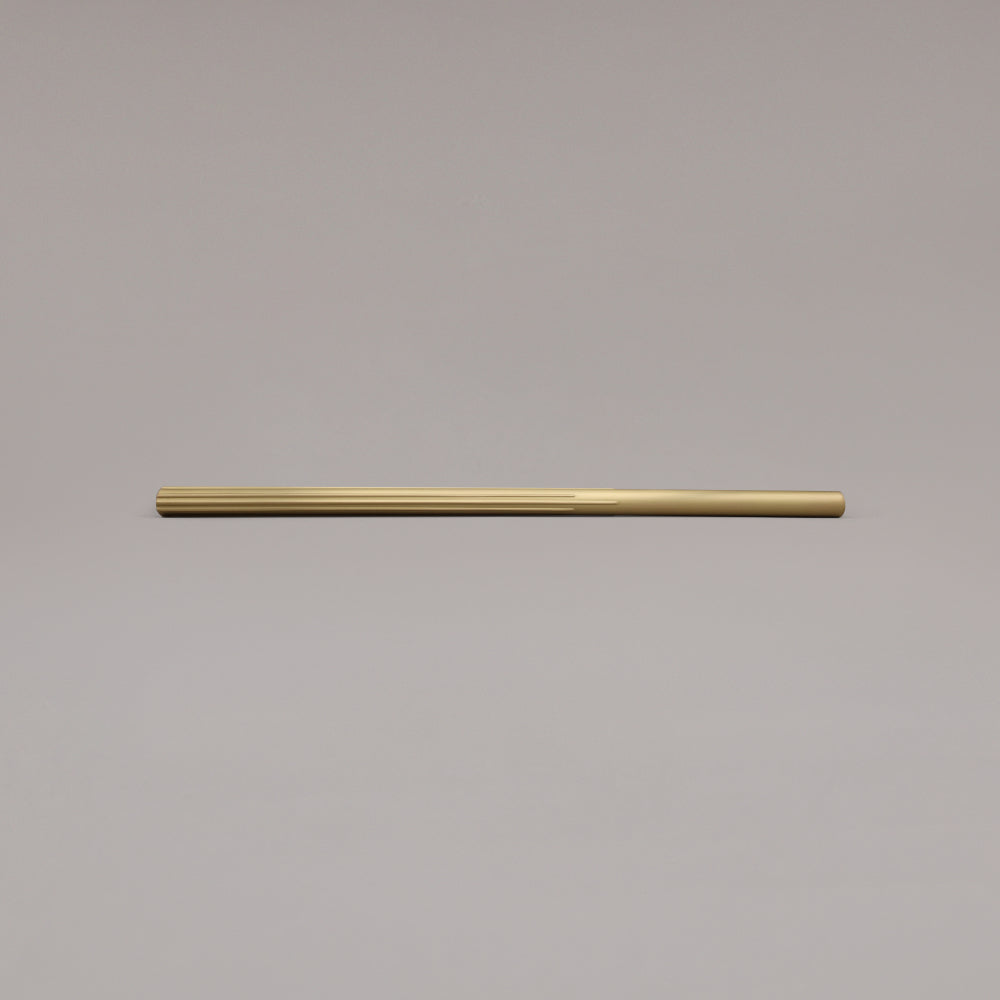 18" Sunburst appliance pull in Satin Brass laying on gray background