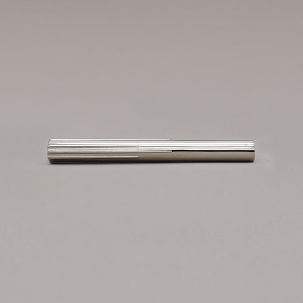 small polished nickel sunburst pull laying on gray background