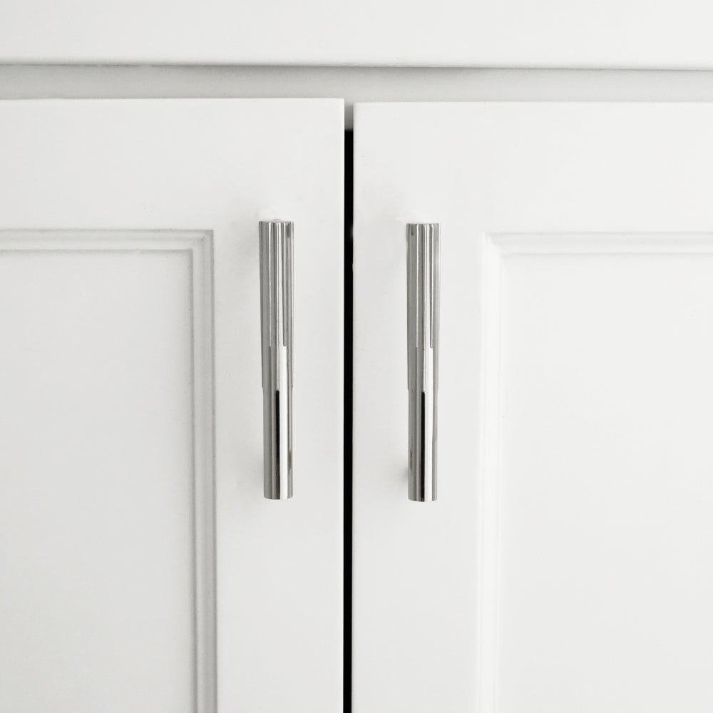 sunburst polished nickel cabinet pulls installed on white cabinet