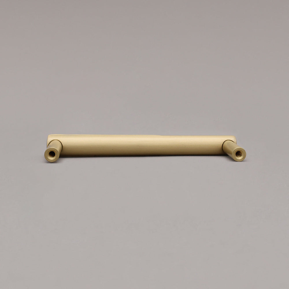 Rear view of satin brass gold sunburst cabinet pull on gray background
