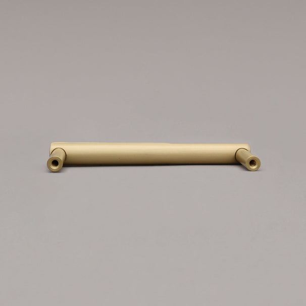 Rear view of satin brass gold sunburst cabinet pull on gray background