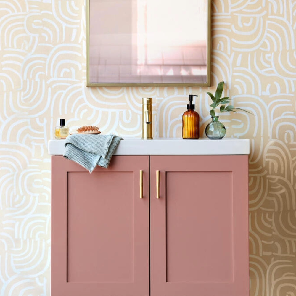 Sunburst satin brass gold cabinet pulls installed on pink bathroom vanity