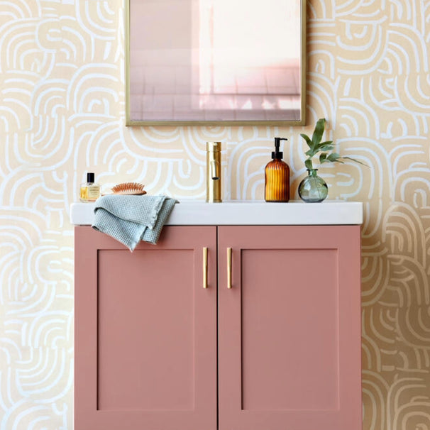 Sunburst satin brass gold cabinet pulls installed on pink bathroom vanity