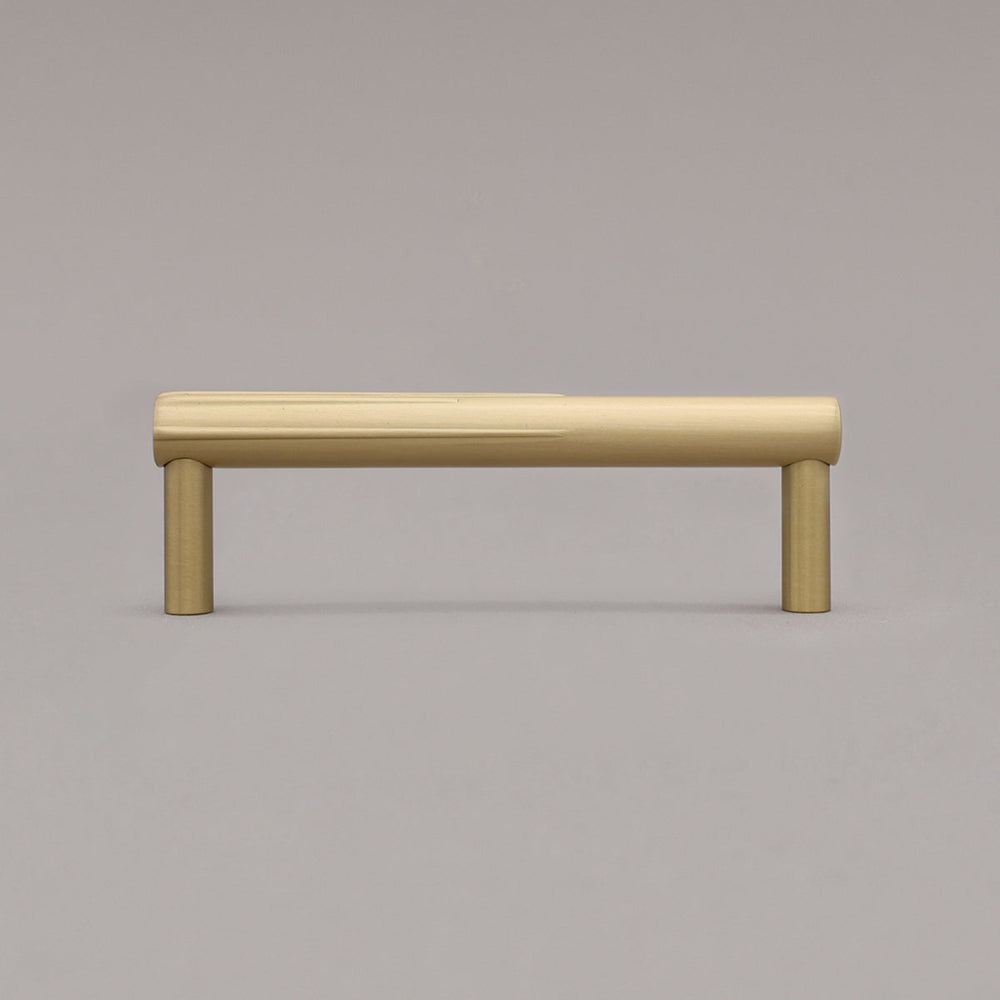 small sunburst satin brass gold cabinet pull standing on gray background