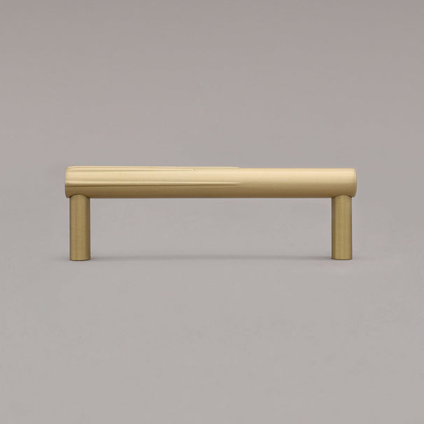 small sunburst satin brass gold cabinet pull standing on gray background