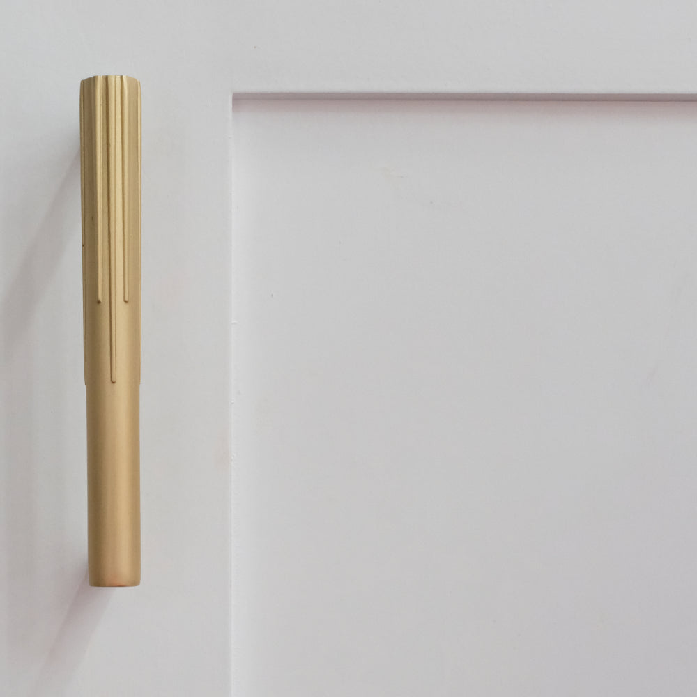 small sunburst cabinet pull in satin brass on white cabinet