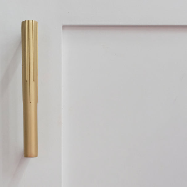 small sunburst cabinet pull in satin brass on white cabinet